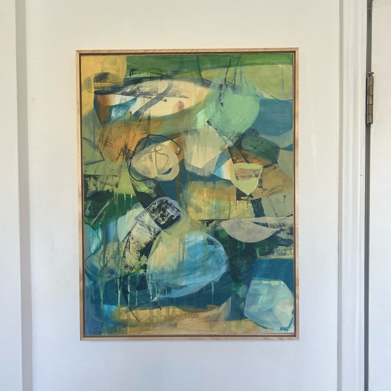 Abstract rectangular painting in blues, ochres, mint and beige in a thin maple frame.