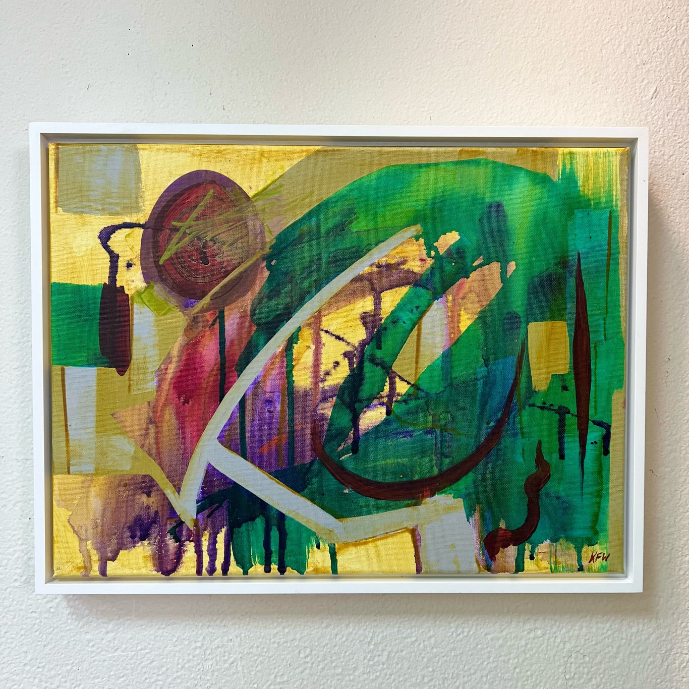 Yellow and green abstract painting in white frame.