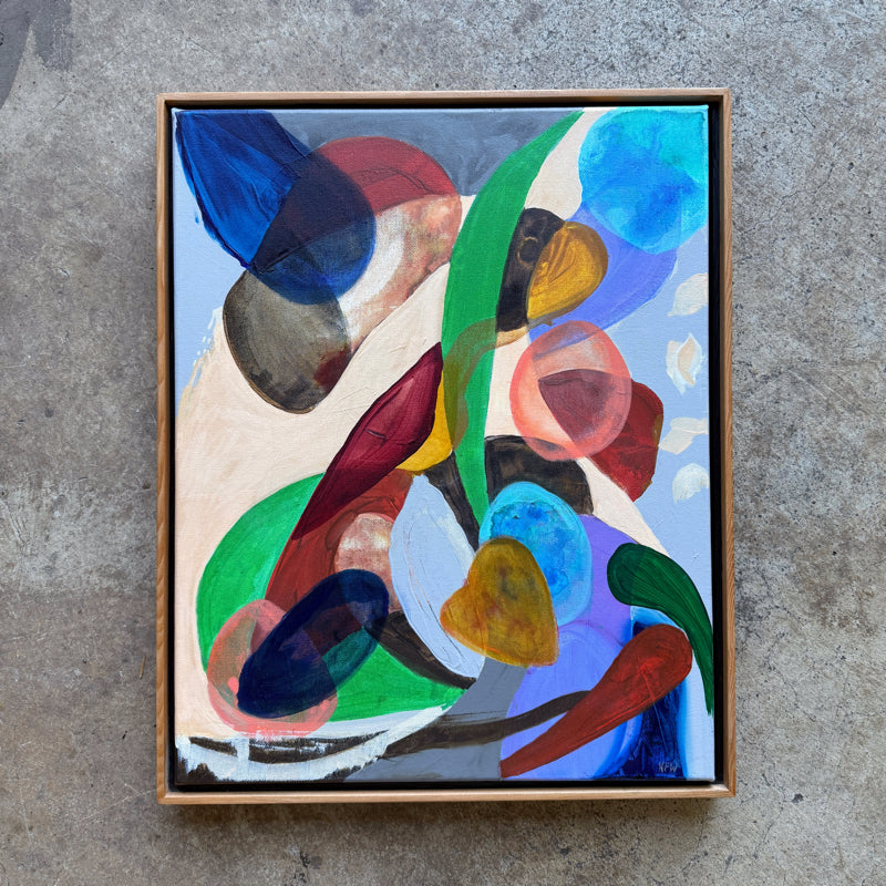 Framed abstract painting with colorful shapes on a concrete surface