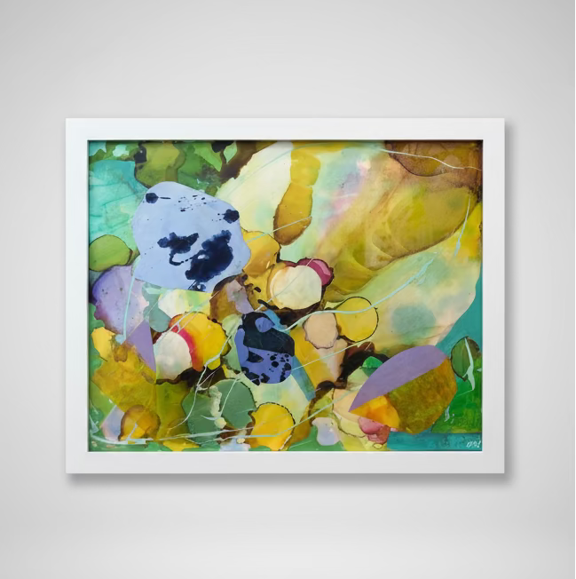 Framed abstract artwork with colorful shapes on a white wall