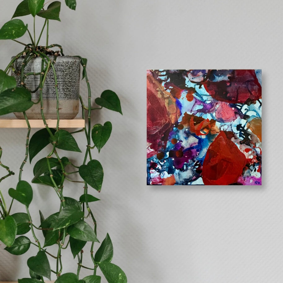 Abstract painting on a wall next to a potted plant