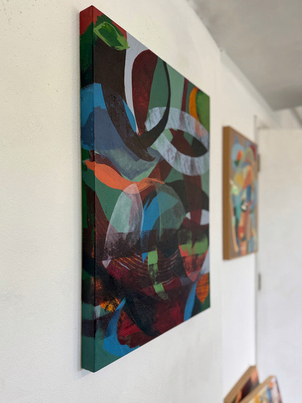 Side view of abstract painting on a wall with other artworks in the background
